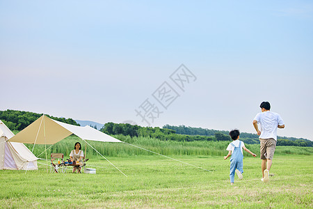 孩子和爸爸小男孩和爸爸在草坪上追逐打闹背影背景