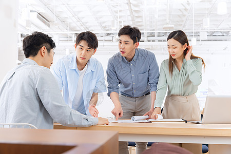 建筑设计师团队探讨装修设计方案图纸背景图片