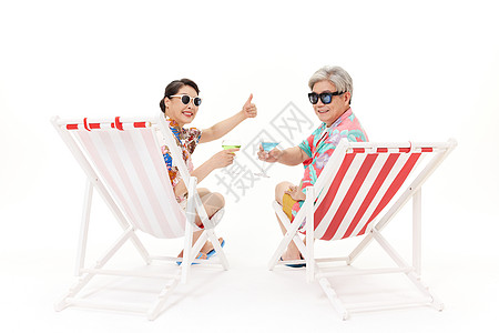 老年旅行度假的恩爱夫妻在躺椅上晒太阳背景