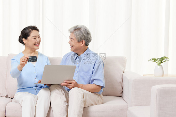 在家使用笔记本电脑上网购物的老年人图片