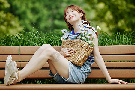 坐在长椅上的夏日美女图片