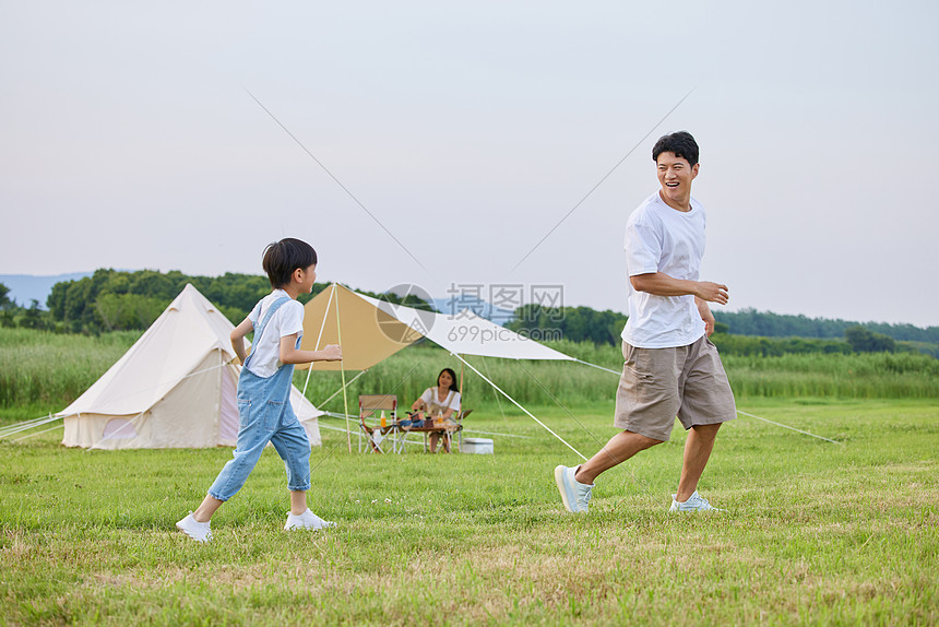 小男孩和爸爸在草坪上追逐打闹图片