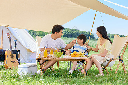 一家三口郊游幸福一家人夏日户外露营背景