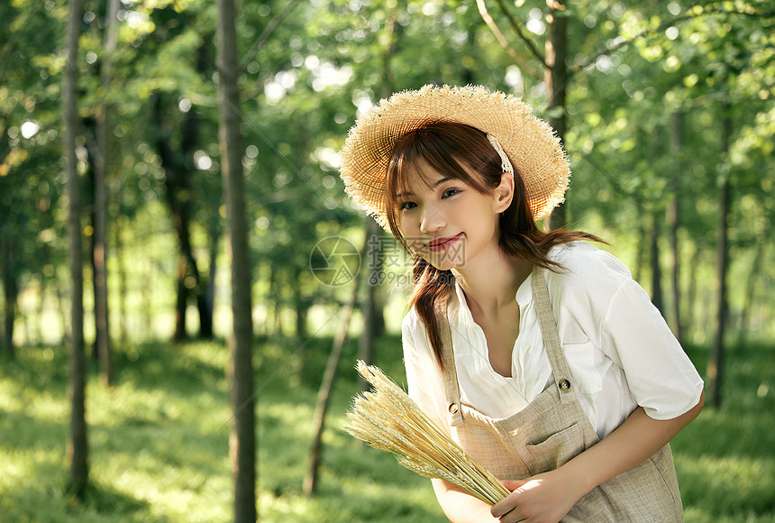 夕阳下手拿麦穗的夏日清新美女图片