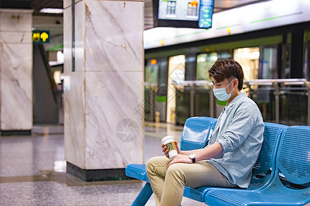 年轻男性坐在地铁站里休息图片