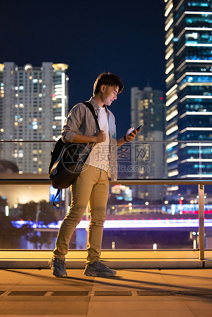 夜晚城市里拿着手机的男性图片