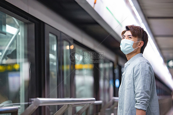 戴口罩等待地铁的男性图片