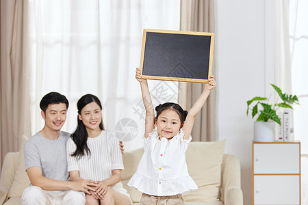 一家人在家里小女孩在家里手举黑板展示背景