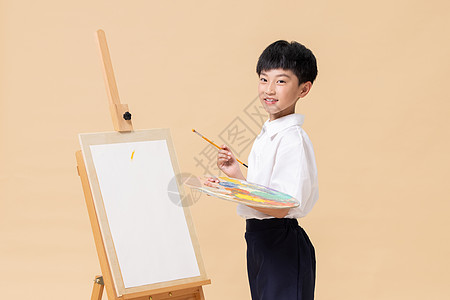 拿着水彩笔画画的小男孩形象图片