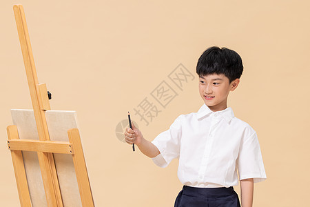小学生画画站在画板前绘画的小男孩背景