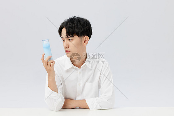 日系男性手拿精华乳液图片