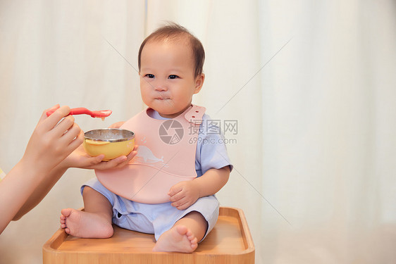 年轻宝妈喂食宝宝吃果泥图片