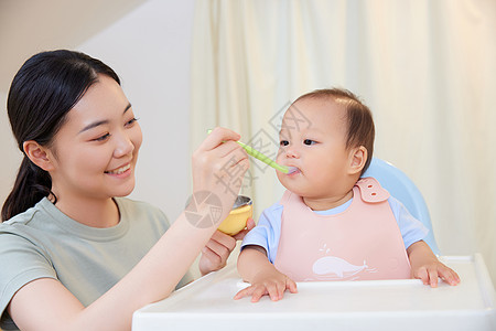 年轻宝妈喂食宝宝吃果泥图片