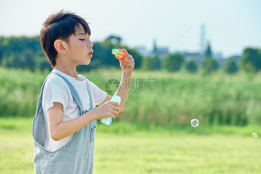 小男孩户外游玩吹泡泡图片