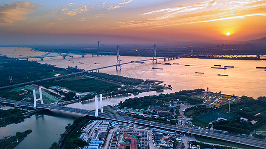 夕阳大桥南京鱼嘴湿地公园与长江边的夕阳晚霞背景