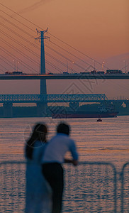 晚霞风景长江边看日落夕阳的情侣背影背景