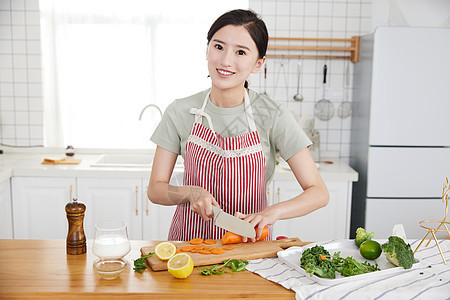 年轻女孩在厨房切菜图片