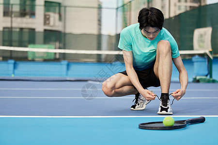打网球的男性系鞋带图片