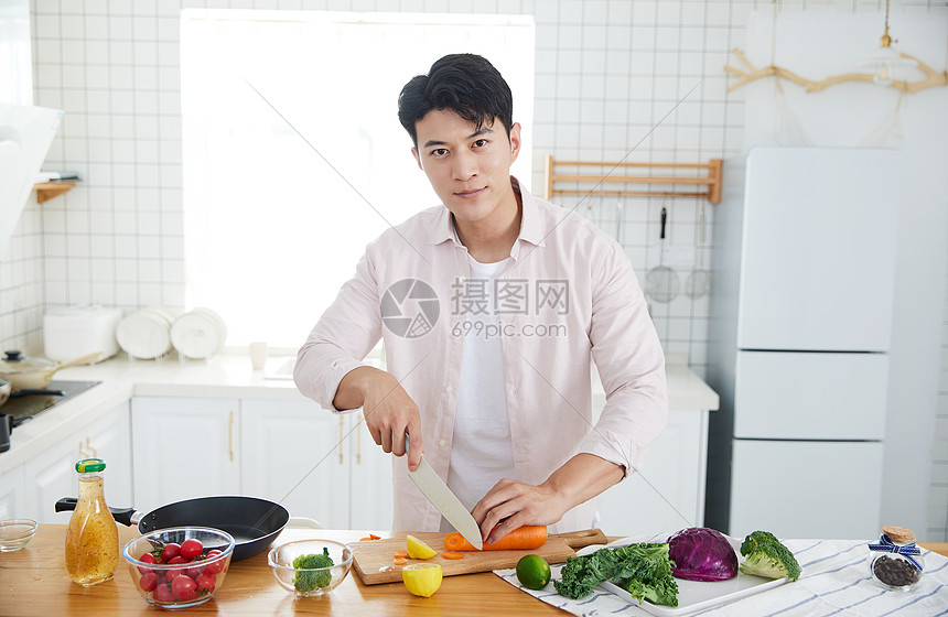 年轻男子在厨房切菜