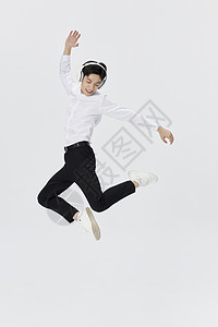 跳跃的年轻人戴着耳机跳跃浮空的年轻人背景