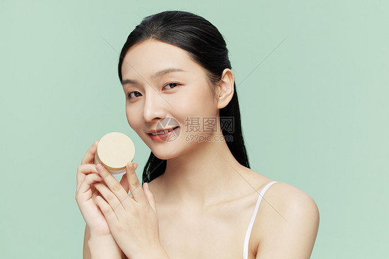 年轻女性手持护肤品护肤图片
