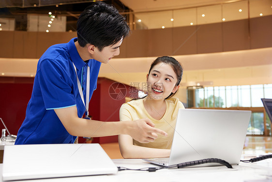 销售员向女大学生介绍新款电脑图片