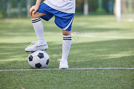 踢足球的小男孩脚部特写背景图片