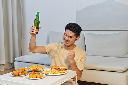 居家男性观看世界杯喝啤酒背景图片