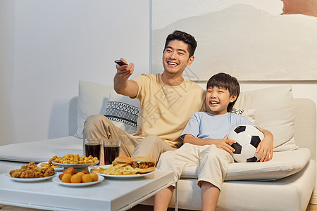 在家看世界杯爸爸和儿子坐沙发上开心看世界杯背景