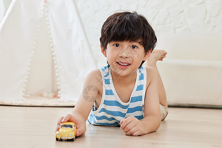玩具小汽车小男孩趴在地板上玩小汽车背景