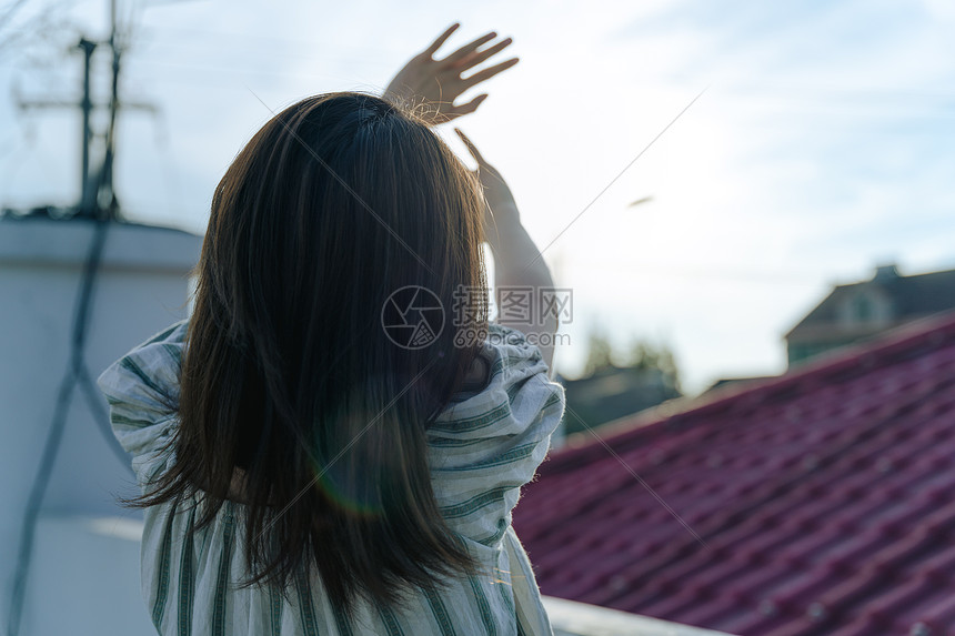 楼顶傍晚逆光的女孩背影图片