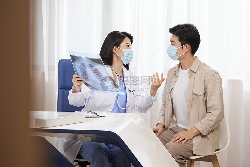 医院里医生拿着x光片与病人交流图片