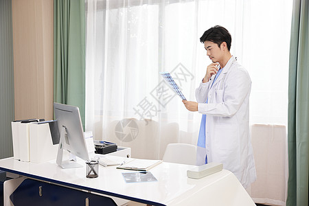 医生在医务室研究x光片背景图片