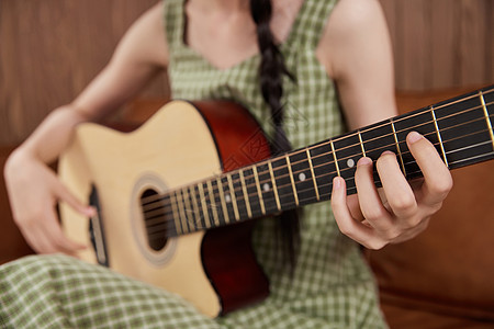 女性弹奏吉他手部特写图片