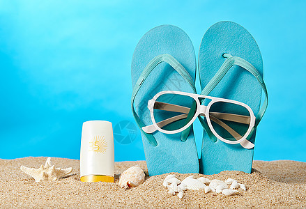 沙滩上的拖鞋墨镜和防晒霜高清图片