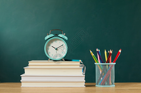 教师节堆叠在桌上的书本和闹钟背景