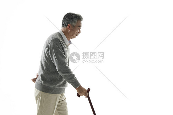 老年男性拄着拐杖行走图片