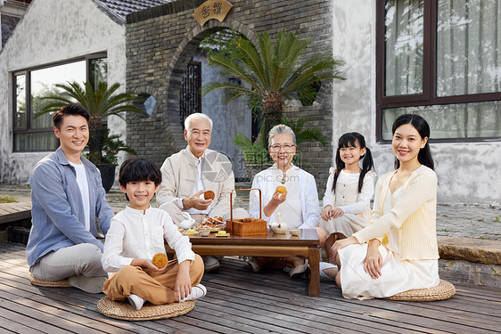 一家六口中秋节庭院聚会吃月饼图片