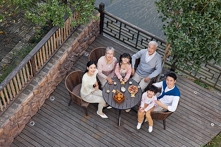 一家六口中秋节庭院聚会吃月饼俯拍图片