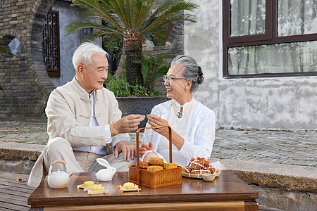 中秋节爷爷奶奶庭院里吃月饼图片