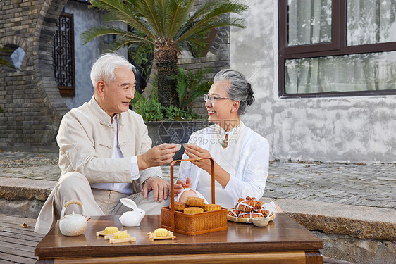 中秋节爷爷奶奶庭院里吃月饼图片