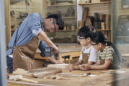技能培训木工师傅教小朋友使用手电钻背景