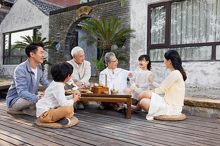 一家人喝水一家人庭院里相聚过中秋节吃月饼背景