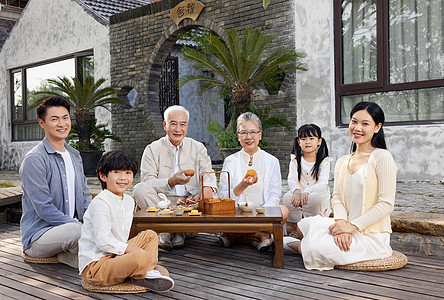 家人团聚一家人庭院里相聚过中秋节吃月饼背景