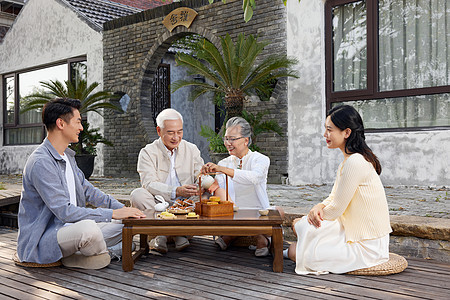 新婚夫妻陪伴老人过中秋节喝茶高清图片