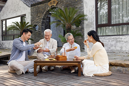 新婚夫妻陪伴老人过中秋节吃月饼图片