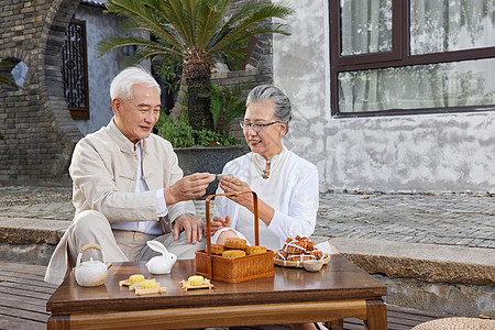 中秋节爷爷奶奶庭院里喝茶高清图片