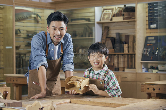 木工老师和小男孩展示木制手工作品图片