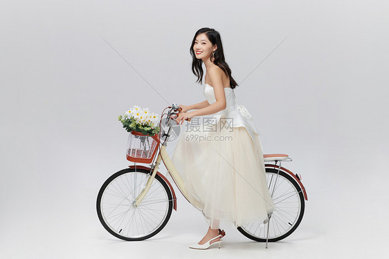 穿着婚纱的女性坐在自行车上图片