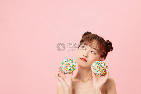 手拿甜甜圈展示的元气美女图片